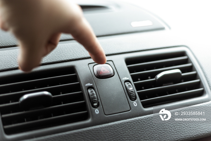 Knopf vom Warnblinker im Auto drücken