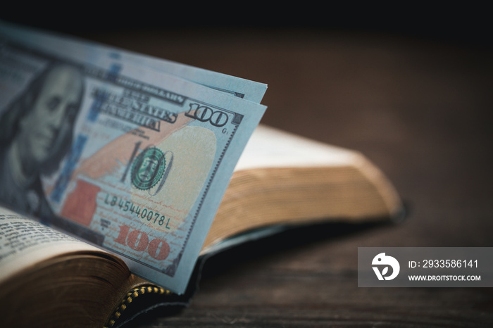 One tenth or tithe is basis on which Bible teaches us to give one tenth of first fruit to God. coins with Holy Bible. Biblical concept of Christian offering, generosity, and giving tithes in church.