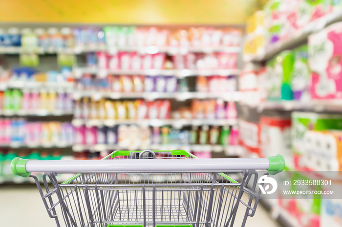 detergent and cleaning product shelves in supermarket or grocery store with empty shopping cart