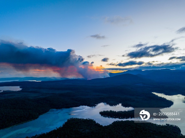 smoke rising over a hill in tasmania australia, from a bushfire in australia in summer.