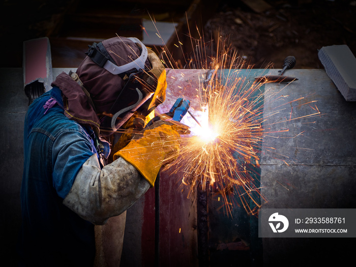 Welder is welding big pipe at construction site