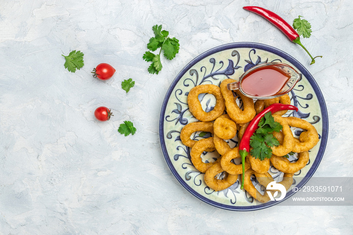 Rings of squid with lemon and sauce on a light background. Snack to beer. banner, menu, recipe place for text, top view