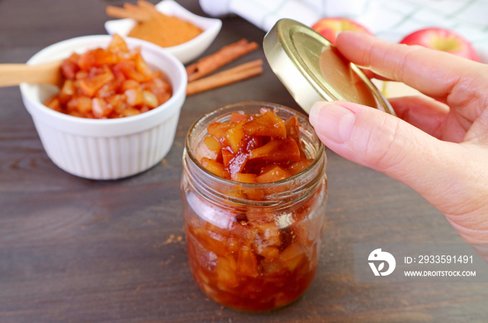 Delectable homemade caramelized apple cinnamon compote being stored in glass jar