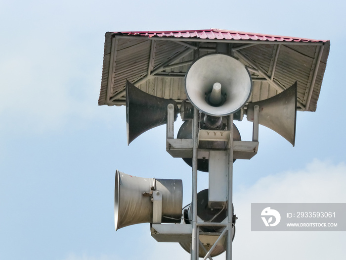 Vintage horn speaker tower with loudspeaker against the sky. System of alert for population.