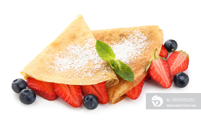 Delicious thin pancakes with fresh berries and mint leaves on white background