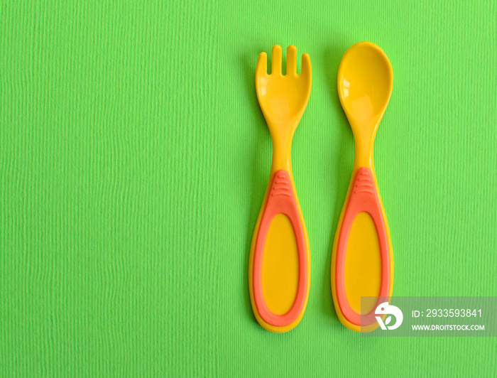 Baby plastic fork and spoon, copy space.