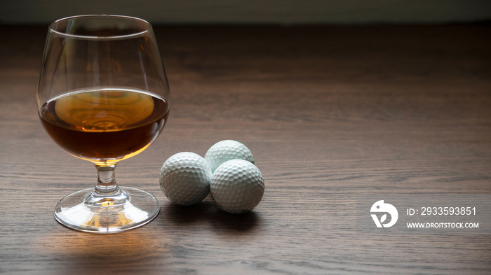 BOURBON CUP WITH GOLF BALLS ON RUSTIC WOODEN TABLE AND SPACE FOR TEXT