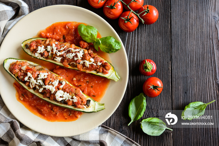 Stuffed zucchini with pork, pepper, garlic, onion and cheese garnished with tomato salsa