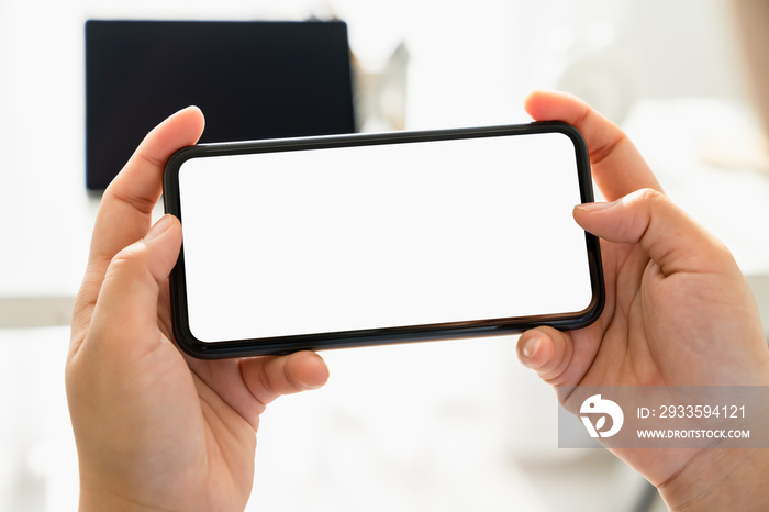 Closeup of young woman hand holding smartphone on the table and the screen is blank, social network concept.