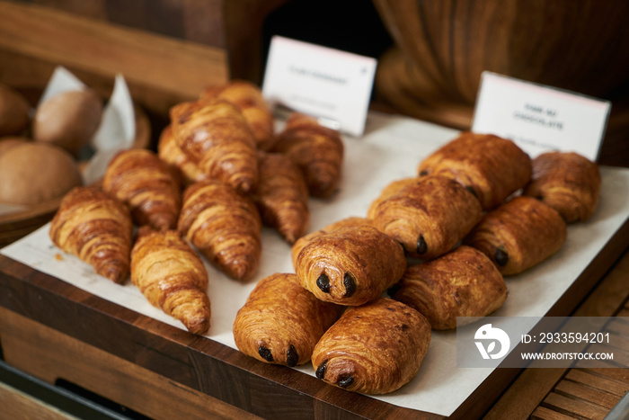 Plain croissant and chocolate puff pastry buns, on restaurant bu