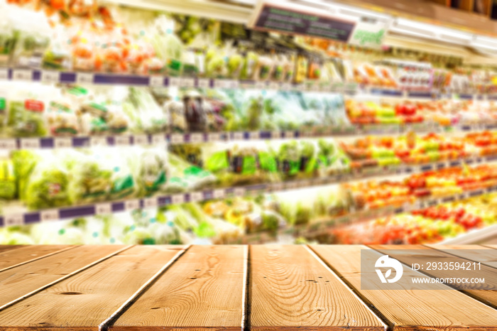 Abstract blur and defocused fruit and vegetables department in supermarket or retail store interior for background and empty wooden table space platform for present product.