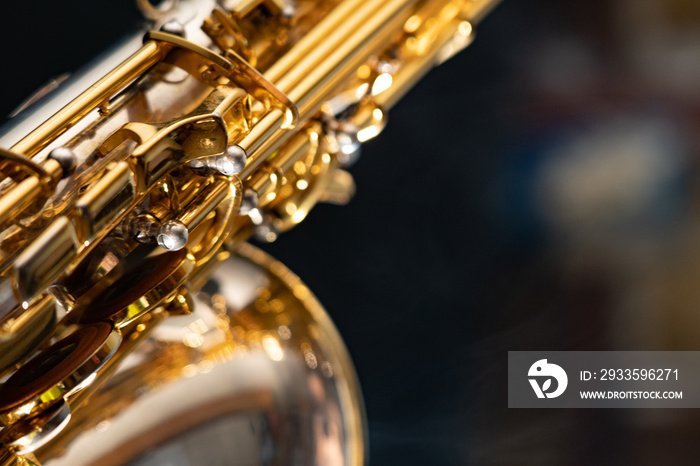 Golden shiny alto saxophone on black background with smoke. copy space