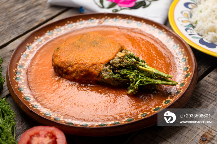 Mexican huazontles with tomato sauce on wooden background