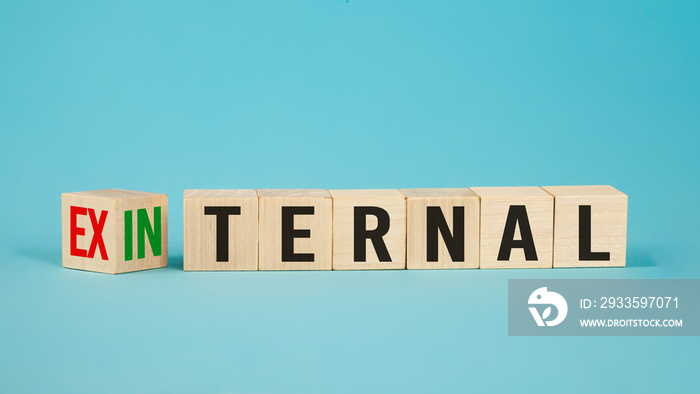 External and internal on wooden cubes, dice or blocks showing the words external and internal on blue background.Business concept.