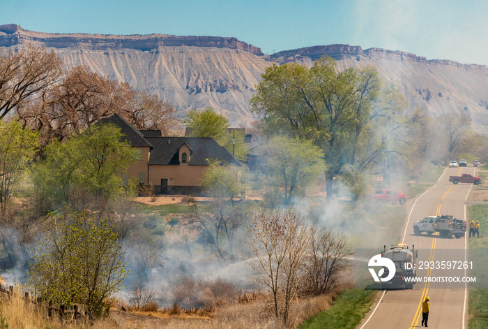 Firefighters Work to Protect Homes from a Wildfire