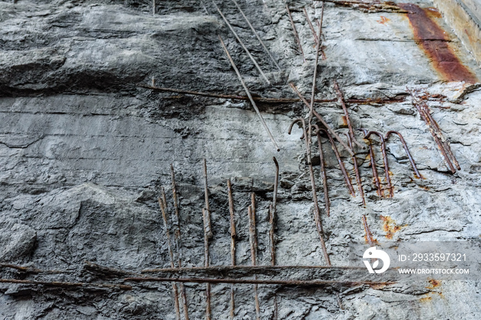 Old damaged concrete wall with rusty armature