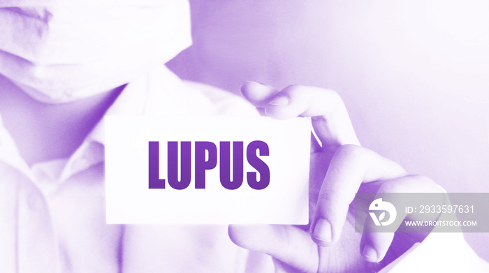 Doctor’s hand shows the card with word lupus. Medical concept