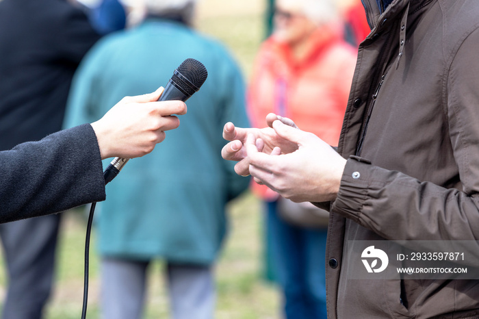 News reporter making media or vox pop interview with unrecognizable person