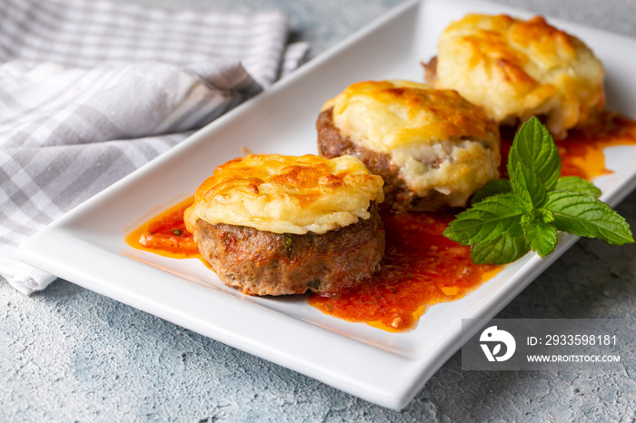 Turkish Food Hasanpasa Kofte - Kofta with Puree - Meatball with Bechamel Sauce and Green Peas. Traditional Food.