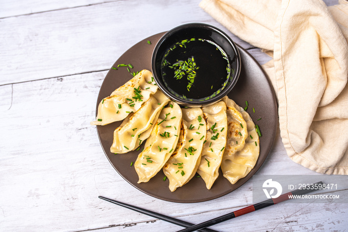 Homemade fried Asian potsticker dumpling appetizer. Gyzo Asian Pork Potstickers with Soy Sauce. Dumplings on a plate.