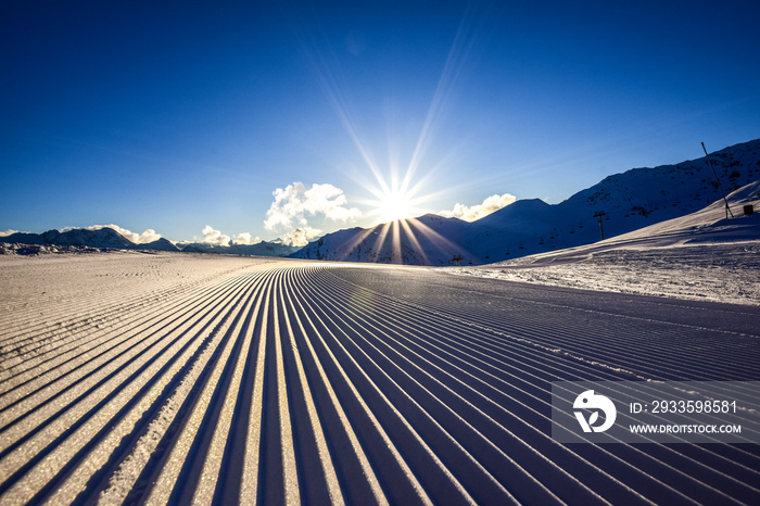 Close up of a freshly prepared skiing slope in the evening sun in the Zillertal skiing area in Austria, Europe. The piste is prepared with a snow grooming machine to ensure perfect conditions.