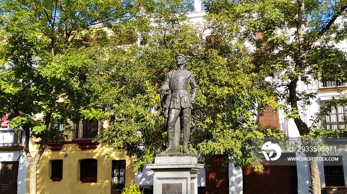 Monument to Don Juan Tenorio in a square of Seville, Spain - statue with trees and houses in the background