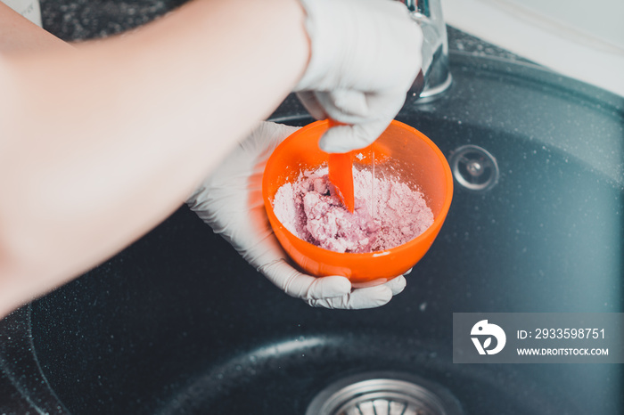 Alginate impression, orthodontist prepares a pink mixture to measure the patient’s mouth