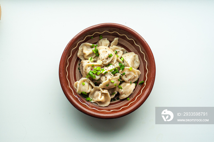 a classic traditional dish of pelmeni dumplings with meat, butter, pepper and greens, food of the countries of the world, gastrotourism