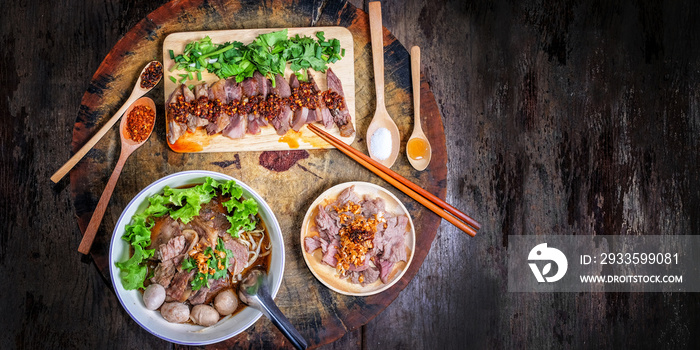 Thai noodle with meatballs and sliced grilled beef on wood background