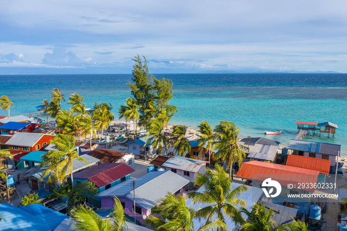 Aerial drone image of beautiful white sandy beach tropical island with turquoise sea water and Malay traditional fisherman village at Mantanani Island, Sabah, Borneo - Travel Concept