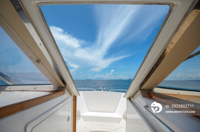 A view of front luxury speedboat with a beautiful ocean and mountain in background