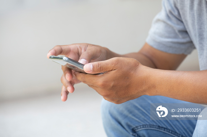 Closeup hand of Asian man teen using smart phone with space.