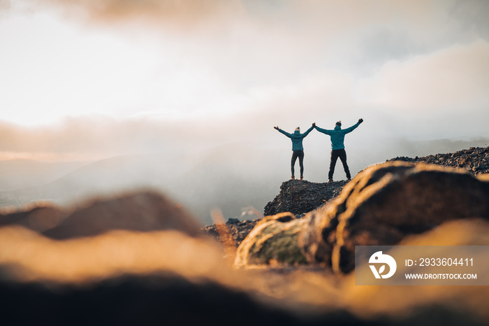 Couple travelers Man and Woman standing on cliff relaxing mountains and clouds aerial view Love and Travel happy emotions Lifestyle concept. Young family traveling active adventure vacations