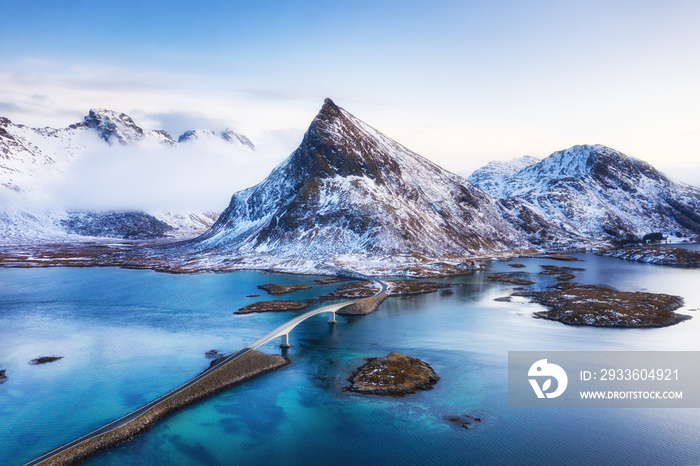 View from the air on the bridge and mountains during sunset. Lofoten Islands, Norway. Landscape from the drone. Panorama of mountains, roads and ocean.