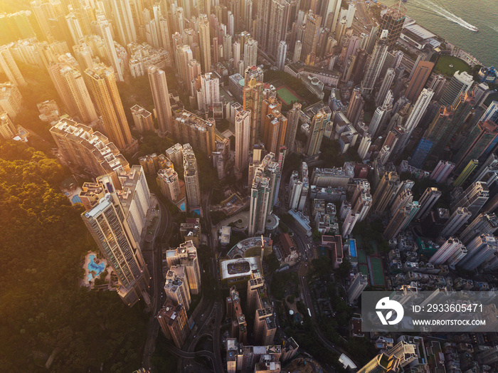 Aerial view of Hong Kong Downtown at sunset. Financial district and business centers in smart city in Asia. Top view of skyscraper and high-rise buildings.