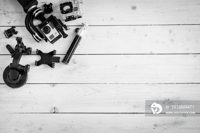 Action camera on the wooden table with a stabilizer and other accessories