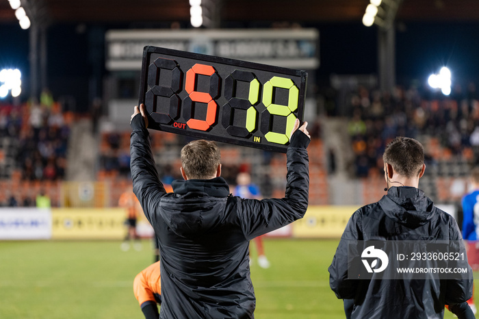 Man shows players substitution during football match.