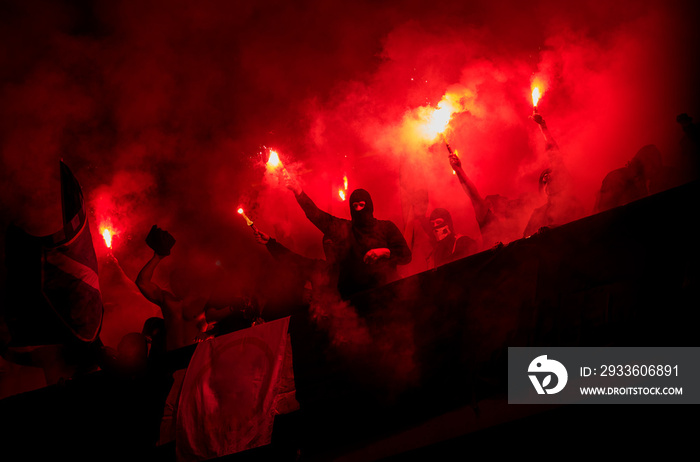 football hooligans with mask holding torches in fire