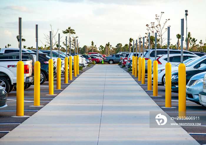 A parking lot has two rows of parking spaces designated for handicap parking; both rows of spots are completely full