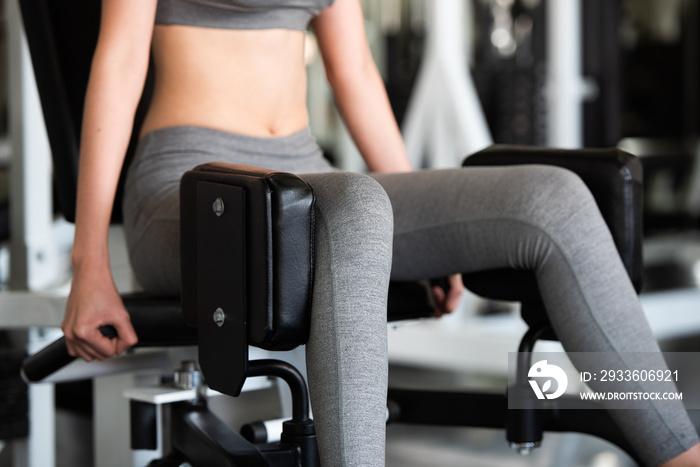 Female doing weight exercise for legs by Inner Thigh Machine in the sports gym, bodybuilder concept.