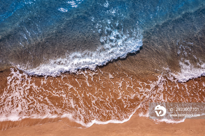 Turquoise water wave with sand beach background from aerial top view. Concept summer sunny travel image