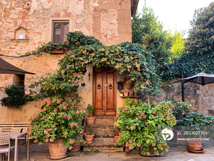 Pienza, Tuscany, Italy. Old house facade in Pienza. Beautiful Italian street of small old provincial town. Street view and facade of old house. Villages in Val dOrcia national park. Woode