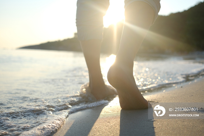 woman walking to sea and beach on a beautiful island Ocean foam wrapped around a girl’s leg. Her legs touched the splashing water. Hit the skin on the legs and she walked in the soft sunshine morning