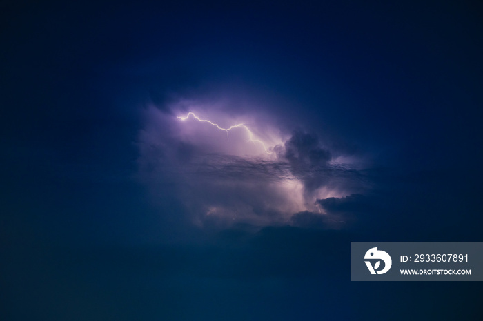 Dramatic view of heat lightning storm, thunderbolts and dramatic clouds at night time