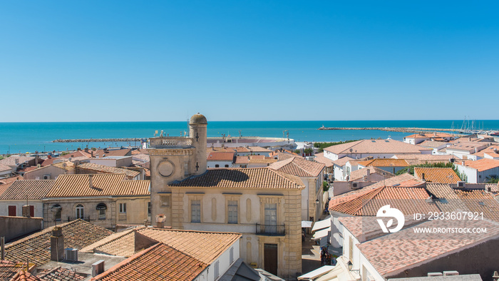 Saintes-Maries-de-la-Mer in Camargue, panorama of the town, tiles roofs, and the sea, view from the church