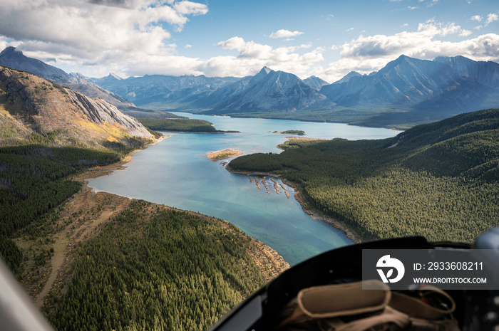 Inside of helicopter flying on rocky mountains with colorful lake