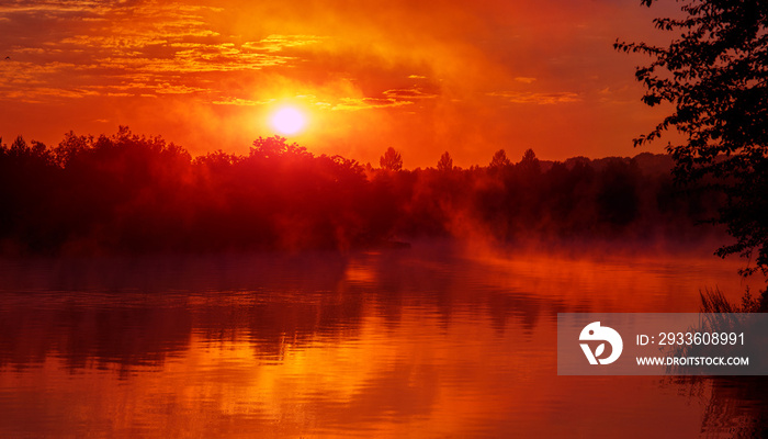 wonderful misty morning. majestic red sunrise over the foggy lake