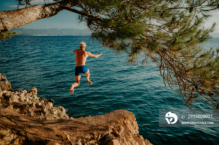 Sport at Summer Vacation in Croatia. Man jumping to the water and enjoy holiday