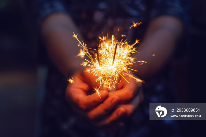 Christmas, New year sparkler in woman hands.