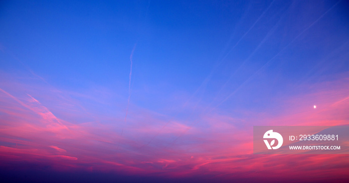 Sunset with pink clouds, light rays and other atmospheric effect.